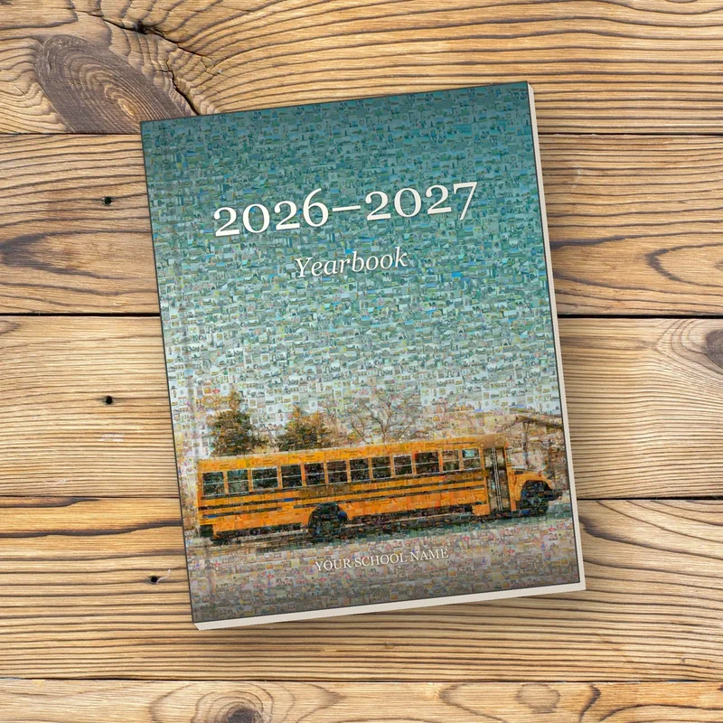 A hardcover yearbook on a wooden table, its cover a photo mosaic of a yellow school bus made from a whole school year of student photos
